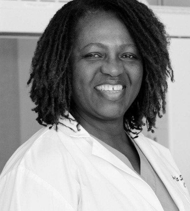 Black woman smiling with nursing coat