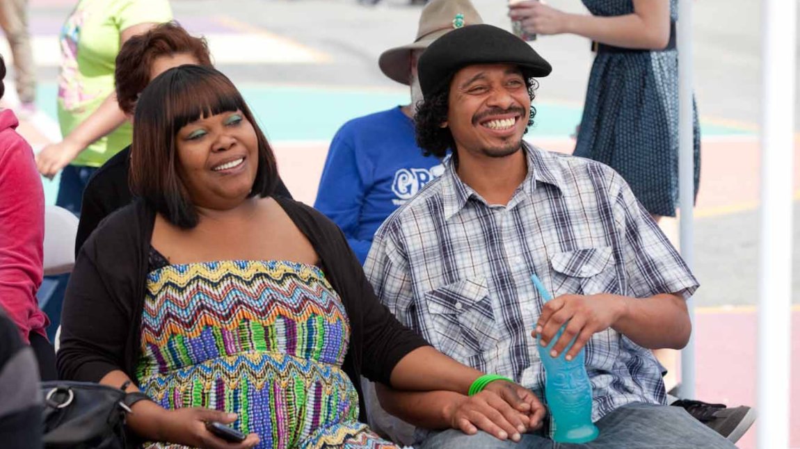 Smiling Black couple seated at outdoor event